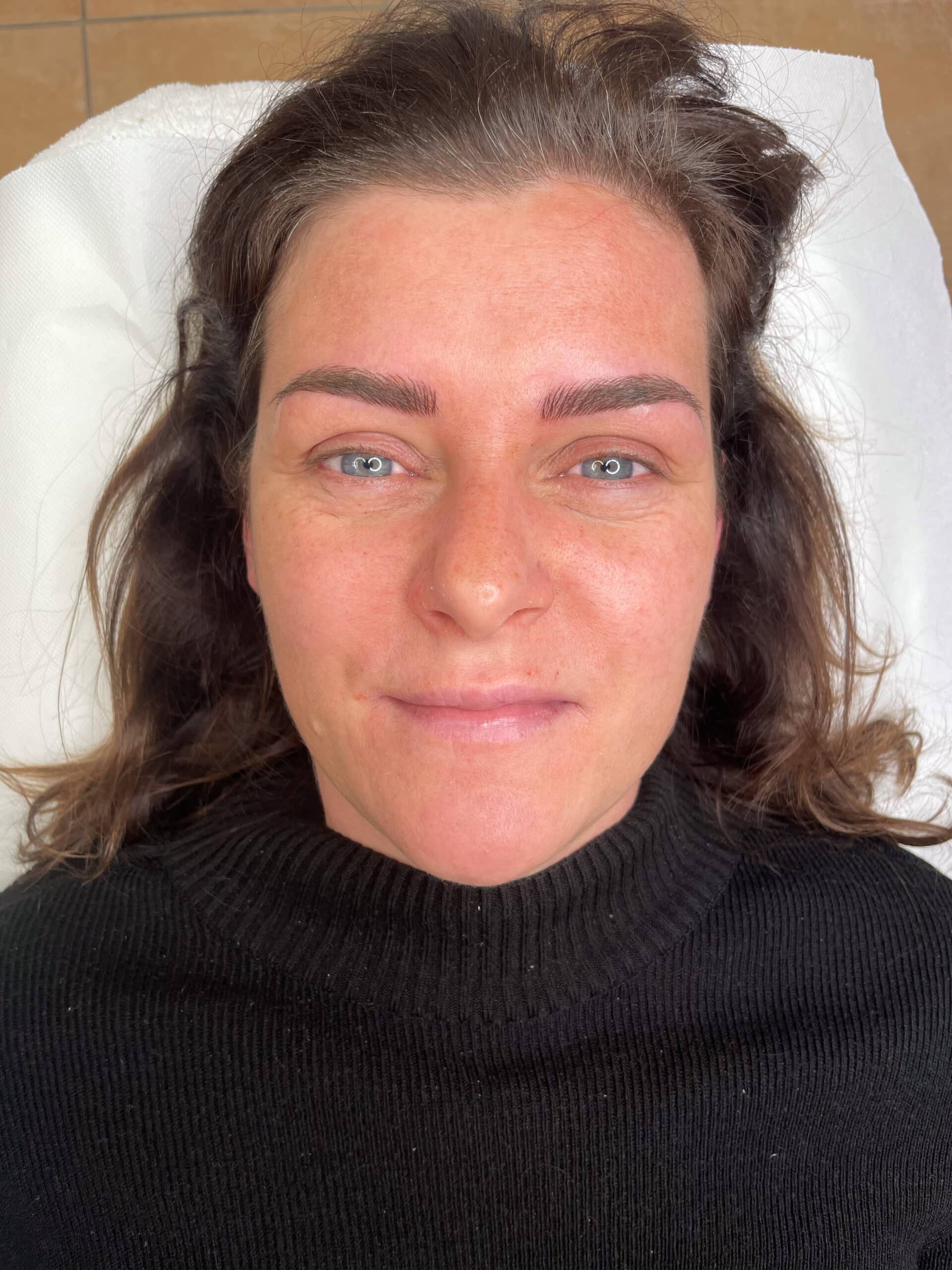 Augenbrauen Nachher Bild Microblading Ergebnis von junger Frau auf der Liege 